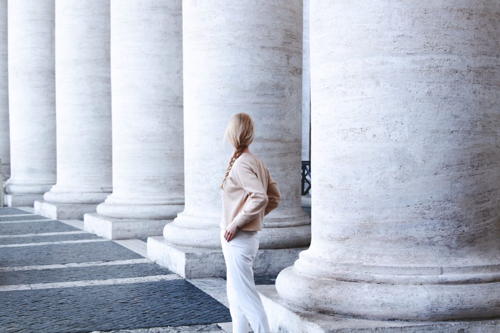 photo-of-woman-standing-beside-concrete-pillar